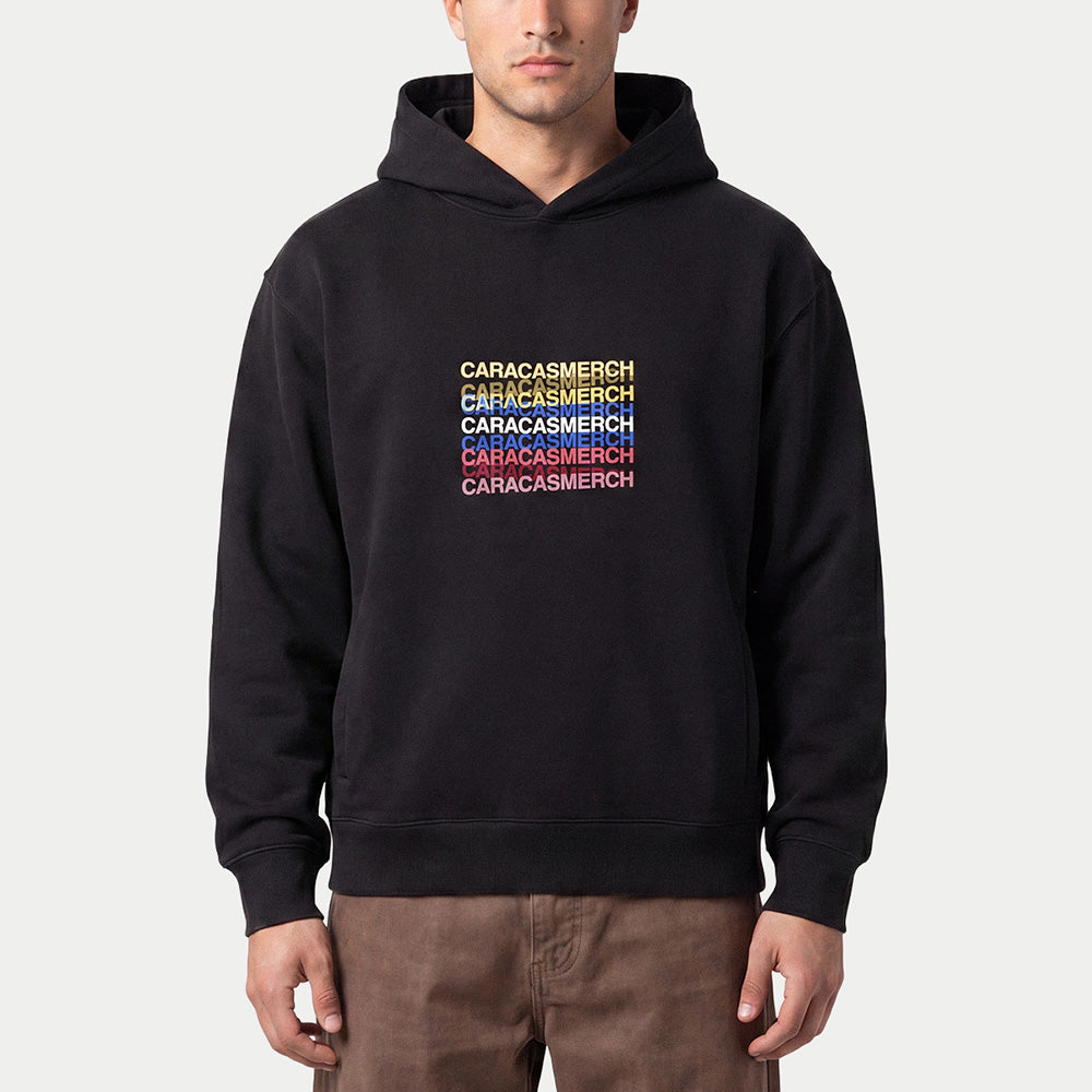 Man wearing the black Caracas Merch tricolour hoodie with brown trousers